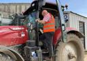 Andrew Francis applies a UK Power Networks overhead cables warning sticker to a tractor cab