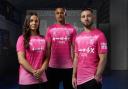 Maria Boswell, Ali Al-Hamadi and Conor Chaplin model Ipswich Town's pink third shirt.