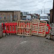 Residents add pallets as barriers to block traffic.