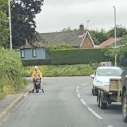 One of the pavements in Bramford, with a pedestrian walking on the road