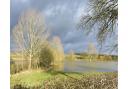 Last of the day's sunlight falls on the soaked fields near Framlingham