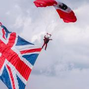 The paratroopers arrive for the pageant carrying the Union flag