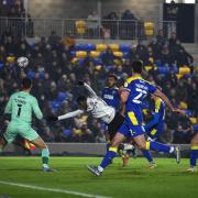 Tyreeq Bakinson heads wide but alleged that his shirt was pulled at AFC Wimbledon.