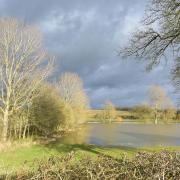 Last of the day's sunlight falls on the soaked fields near Framlingham