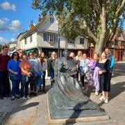 Young people at the Thomas Wolsey statue in Ipswich town centre.